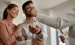 Happy couple getting keys to their new house
