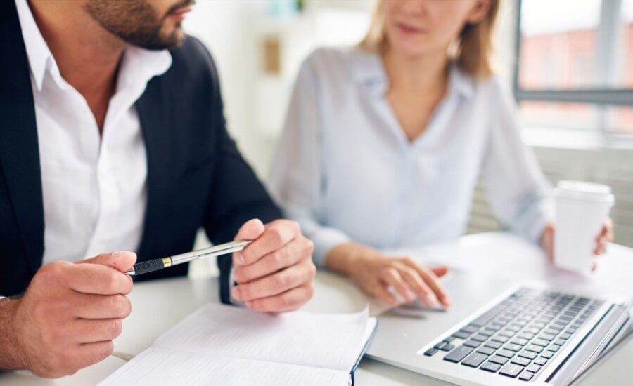 Man and woman sitting at a desk with a laptop