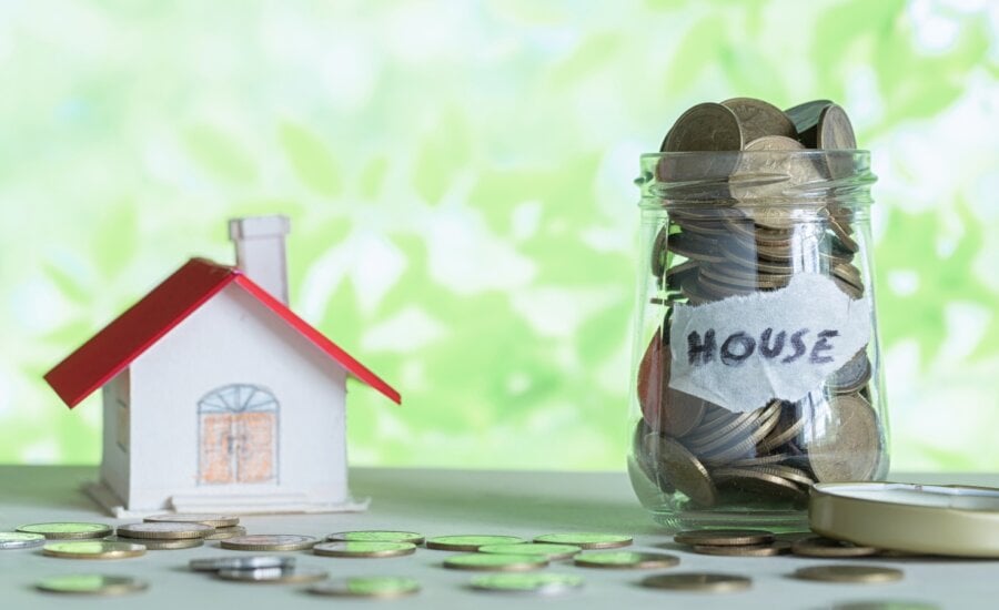 Money saving for house in the glass bottle. Saving money for buy home concept