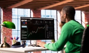 Man sitting at a computer watching stock performance