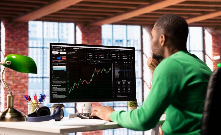 Man sitting at a computer watching stock performance