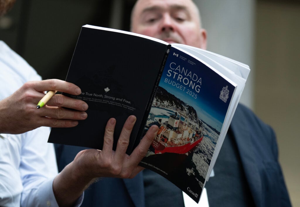Reporters read over the federal budget as they prepare for its release in Ottawa, Tuesday, Nov. 4, 2025.