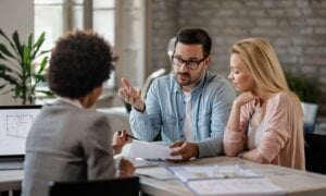 Couple sitting at a desk across from financial planner