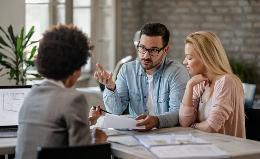 Couple sitting at a desk across from financial planner