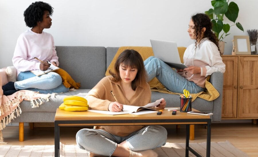 Three female roommates sitting in a living room