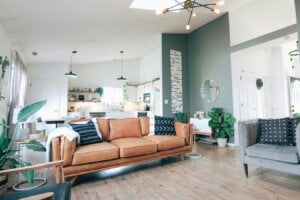 The main living room of a house is seen with sofas and plants.