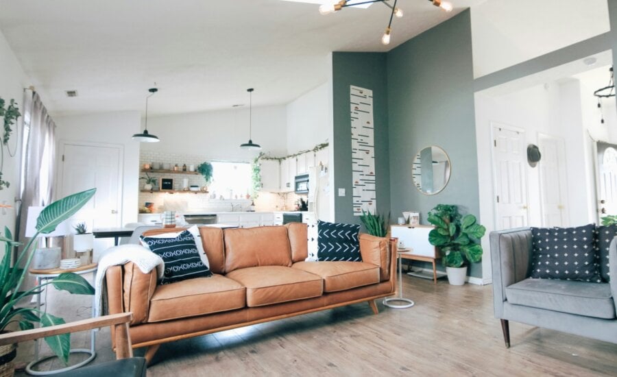 The main living room of a house is seen with sofas and plants.