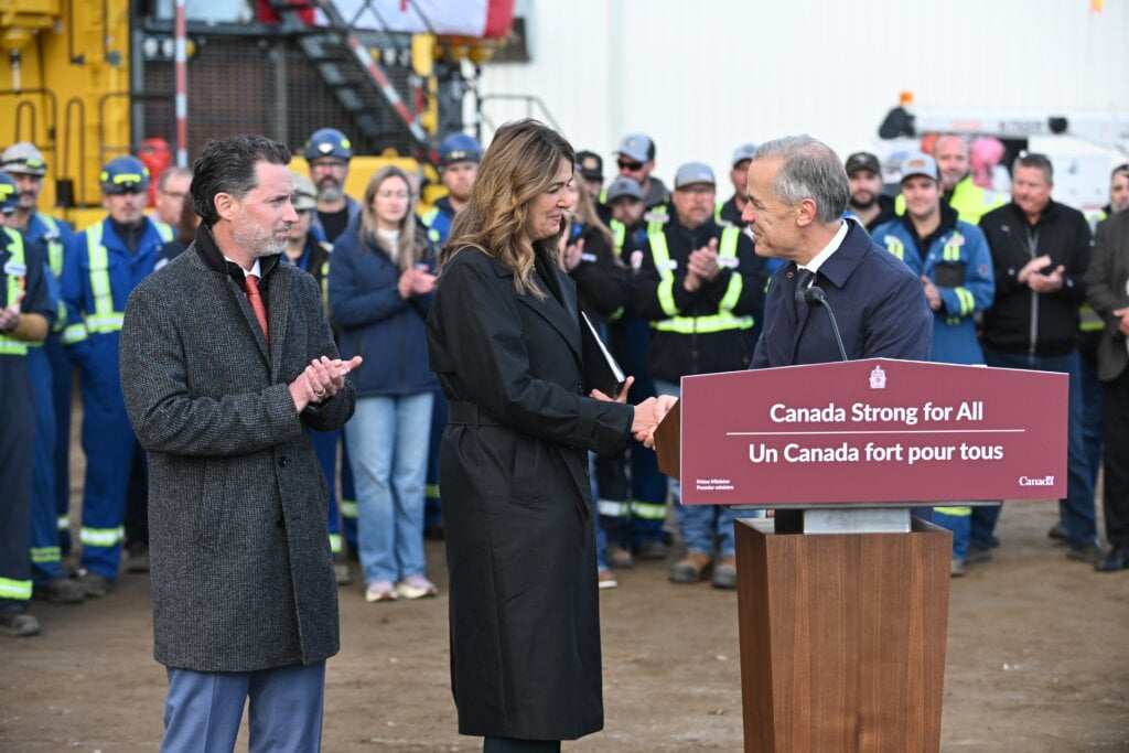 From left, Scott Burrows, CEO of the Pembina Pipeline Corp, Alberta Premier Danielle Smith and Prime Minister Mark Carney shake hands after speaking in Fort McMurray on Thursday Oct 1, 2026. Prime Minister Mark Carney declared the Pacific Link pipeline project to be in the national interest.