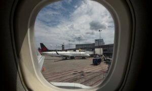 An Air Canada plane sits by its gate as it waits to depart Montreal-Trudeau International Airport in Montreal on Thursday, July 30, 2026.